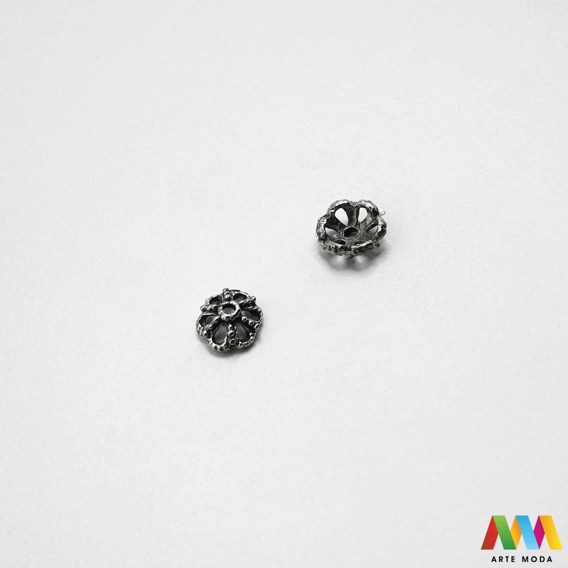 Luksuzne metalne filigranske ljevane kapice za perle u srebrnoj zlatnoj i brončanoj boji izložene Prikazane su čvrste i detaljno lijevane ornamentne kapice krunice i zvonoliki ukrasi koji obujmljuju okrugle staklene drvene i kamene perle pri izradi nakita Vrhunski metalni repromaterijal i masivniji dekorativni razdjelnici s preciznim rupama za nizanje namijenjeni za izradu unikatnih ogrlica narukvica i visećih naušnica u DIY radionicama za ručnu izradu modnog i vintage nakita arte moda repromaterijali