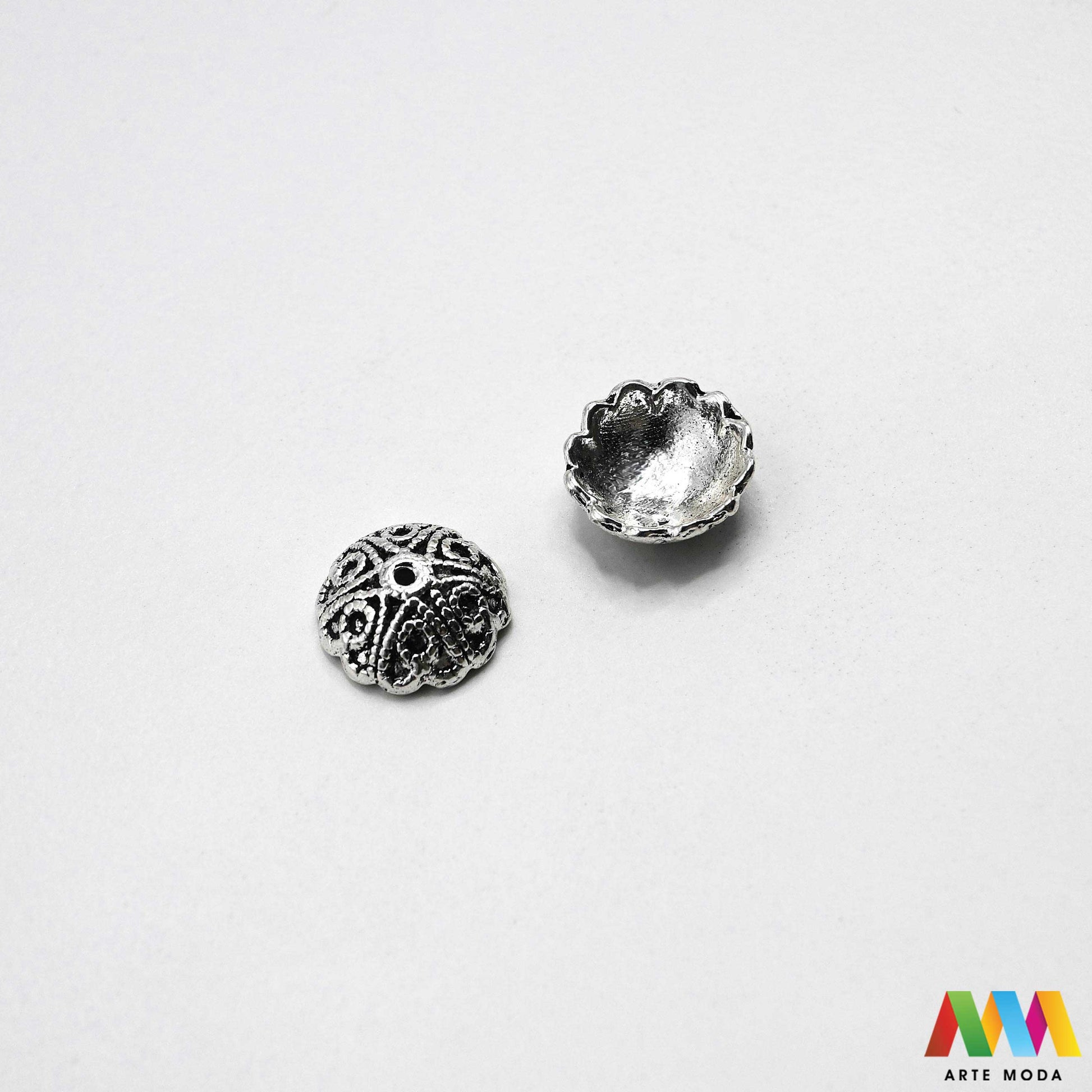 Luksuzne metalne filigranske ljevane kapice za perle u srebrnoj zlatnoj i brončanoj boji izložene Prikazane su čvrste i detaljno lijevane ornamentne kapice krunice i zvonoliki ukrasi koji obujmljuju okrugle staklene drvene i kamene perle pri izradi nakita Vrhunski metalni repromaterijal i masivniji dekorativni razdjelnici s preciznim rupama za nizanje namijenjeni za izradu unikatnih ogrlica narukvica i visećih naušnica u DIY radionicama za ručnu izradu modnog i vintage nakita arte moda repromaterijali