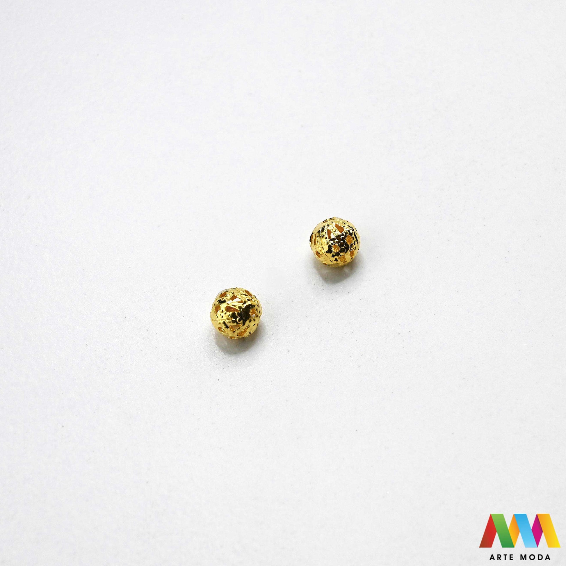 Elegantne metalne filigranske perle u srebrnoj, zlatnoj i nikal boji izložene na površini za izradu nakita. Prikazane su šupljikave i čipkaste metalne kuglice te ovalni filigranski distanceri s raznolikim vintage i orijentalnim uzorcima. Kvalitetan metalni repromaterijal i lagani razdjelnici s izbušenim rupama za provlačenje konca i igala, namijenjeni za izradu unikatnih narukvica, visećih naušnica i bogatih ogrlica u kreativnim DIY radionicama za izradu ručno rađenog modnog nakita arte moda repromaterijali